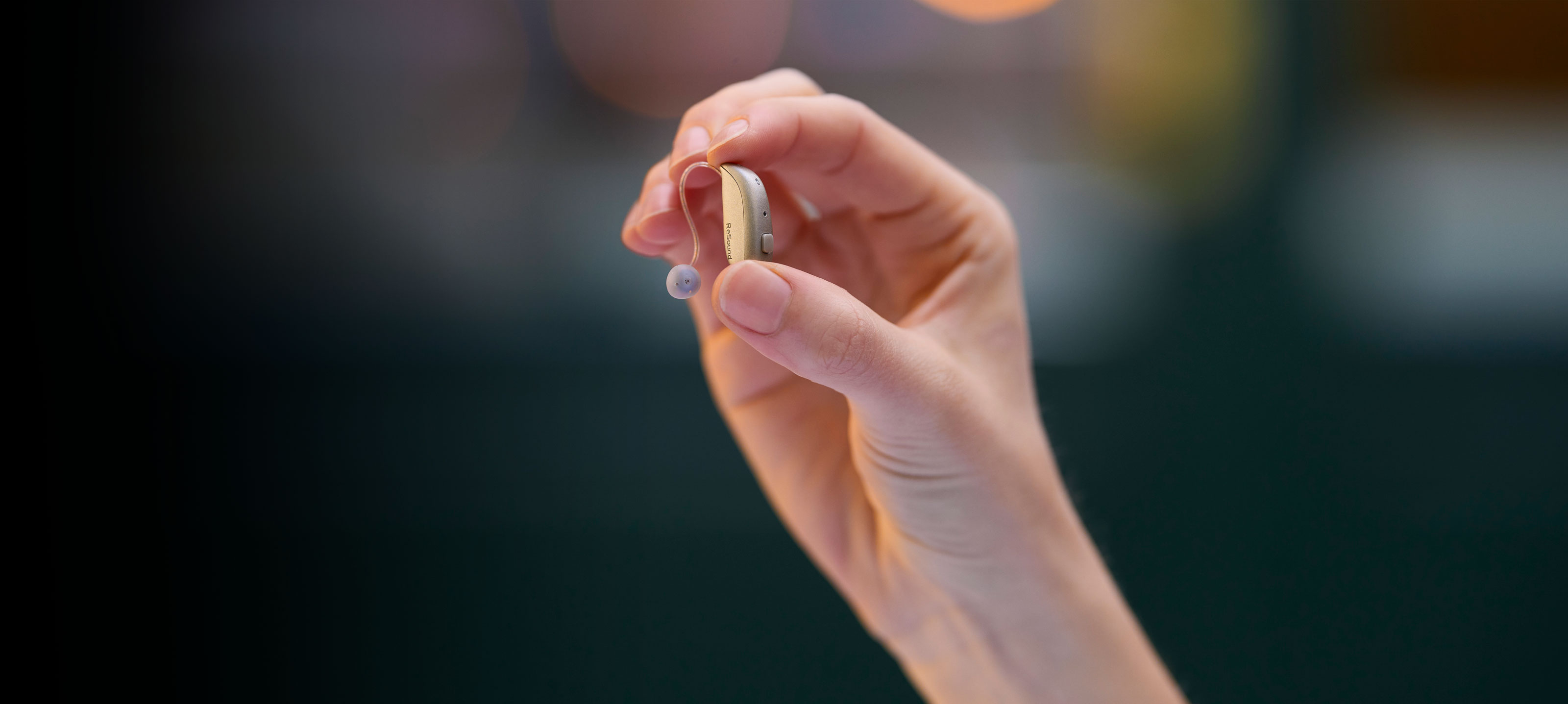 Hand holding hearing aid